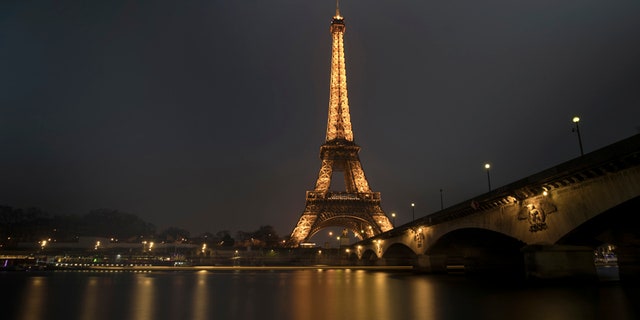A streak of light from a passing boat is seen in this long time-exposure of the illuminated Eiffel Tower and the Seine River in Paris, France, January 17, 2017. REUTERS/Philippe Wojazer - RTSVY77