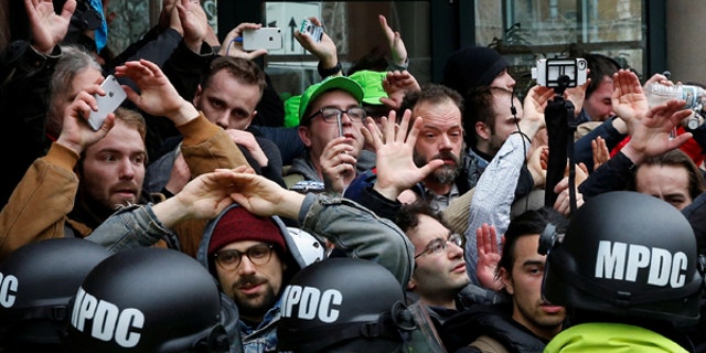 Protesters demonstrating against U.S. President Donald Trump raise their hands as they are surrounded by police on the sidelines of the inauguration in Washington, DC, U.S., January 20, 2017.
