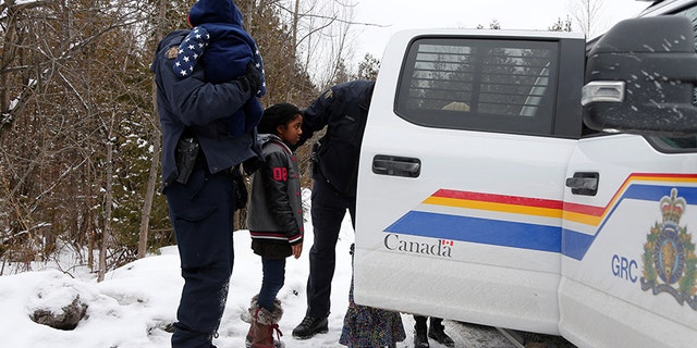 The children of a woman who told police that she and her family were from Sudan are placed in a vehicle as they are all taken into custody by Royal Canadian Mounted Police officers.