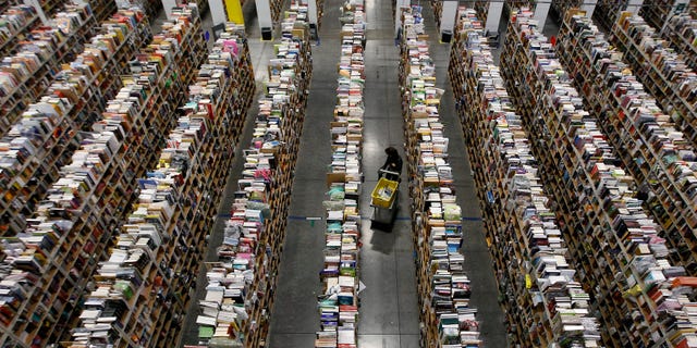 File photo. A worker gathers items for delivery from the warehouse floor at Amazon's distribution center in Phoenix, Arizona November 22, 2013. (REUTERS/Ralph D. Freso)