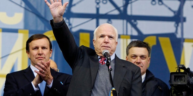 Sen. John McCain waves to pro-European integration protesters during a mass rally in Kiev in 2013.