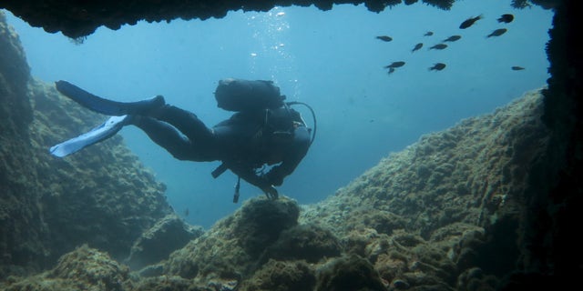 File photo: A scuba diver makes his way out from from an underwater passageway at Isola Bella in Taormina, Italy, at the start of summer holiday season on the Mediterranean island of Sicily July 5, 2015. (REUTERS/John Schults)