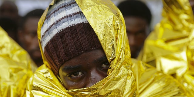 A migrant waits to disembark from a Coast Guard ship in the Sicilian harbour of Messina, Italy August 4, 2015. REUTERS/Antonio Parrinello