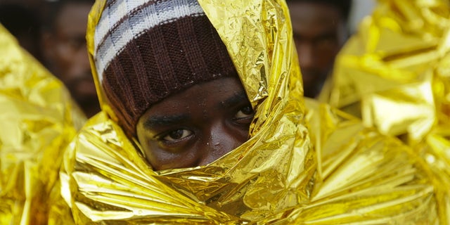 A migrant waits to disembark from a Coast Guard ship in the Sicilian harbour of Messina, Italy August 4, 2015. REUTERS/Antonio Parrinello
