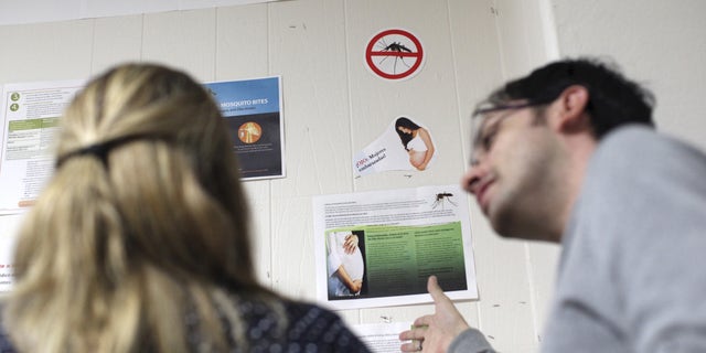 People read information on Zika virus and other mosquito-borne diseases at the Department of Health in San Juan, January 27, 2016. Puerto Rico is to release a report on Zika cases on the island this week which will show that around 18 cases are confirmed, the U.S. territory's health secretary Ana Rius told reporters on Tuesday. REUTERS/Alvin Baez   - RTX24BP6