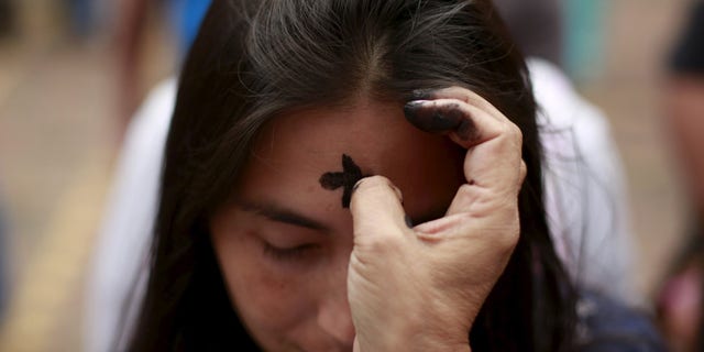 FILE -- A woman receives a cross of ashes during the traditional Ash Wednesday service.