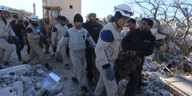 Feb 16., 2016: People and Civil Defense members carry a victim from a destroyed Doctors Without Borders hospital in Syria. (Reuters)