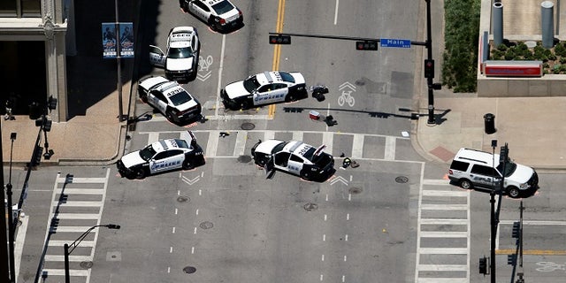 Law enforcement personnel investigate a mass shooting scene at El Centro Community College at the intersection of N Lamar St. and Main St. after an attack which killed and wounded Dallas police officers, in Dallas, Texas, U.S., July 8, 2016. REUTERS/Brandon Wade TPX IMAGES OF THE DAY - RTX2KEX4
