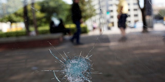 Broken glass from a bullet hole is seen at a bus stop near the shooting scene in Dallas, Texas, U.S., July 8, 2016. REUTERS/Shannon Stapleton - RTX2KEY1