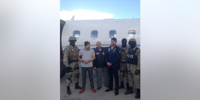 Efrain Antonio Campo Flores (2nd from L) and Franqui Francisco Flores de Freitas stand with law enforcement officers in this November 12, 2015 photo after their arrest in Port Au Prince, Haiti.