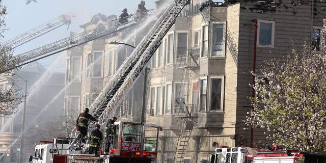 Firefighters battle a four-alarm blaze in a three-story apartment building in Oakland, Calif., March 27, 2017.