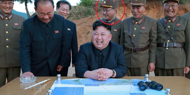 Kim Jong Sik, pictured above, stands with North Korean leader Kim Jong Un as they react during the long-range strategic ballistic rocket test launch.