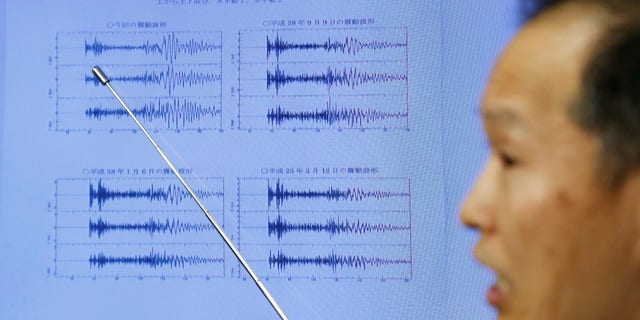 Japan Meteorological Agency's earthquake and tsunami observations division director Toshiyuki Matsumori points at graphs of ground motion waveform data observed in Japan after North Korea's sixth nuclear test.