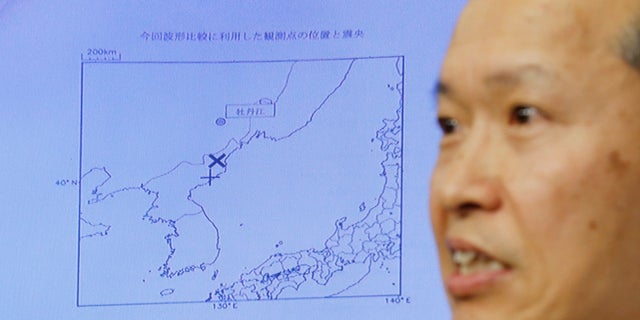 Japan Meteorological Agency's earthquake and tsunami observations division director Toshiyuki Matsumori speaks in front of a screen showing the seismic event that was indicated in North Korea and observed in Japan.