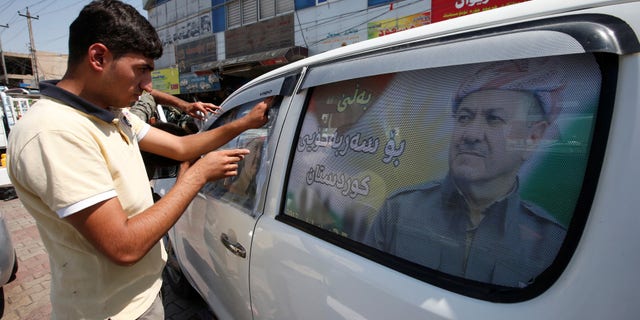 A Kurdish man decorates a car with a poster bearing the image of Iraq's Kurdistan region's President Massoud Barzani, urging people to vote in the September 25th independence referendum, in Erbil, Iraq September 5, 2017.