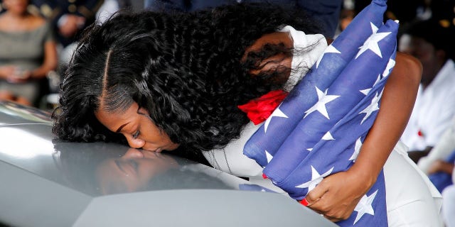 Myeshia Johnson, wife of U.S. Army Sergeant La David Johnson, who was among four special forces soldiers killed in Niger, kisses his coffin at a graveside service in Hollywood, Fla.