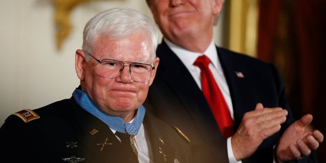 U.S. President Donald Trump claps after awarding the Medal of Honor to Vietnam War Veteran, retired Army Capt. Gary Rose (L), during a ceremony in the East Room of the White House in Washington, DC, U.S. October 23, 2017. REUTERS/Joshua Roberts - RC147FAB9A50