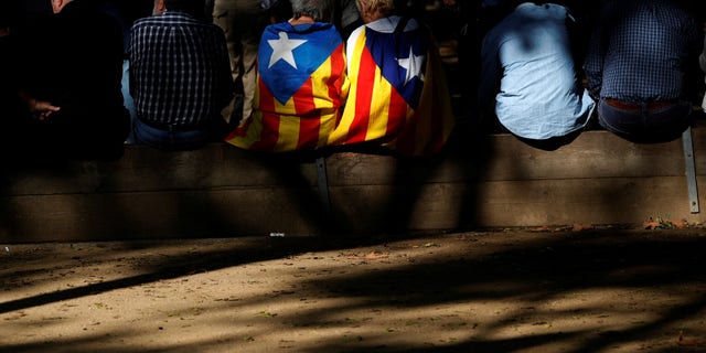 People display Catalan separatist flags during a demonstration outside the Catalan regional parliament in Barcelona.