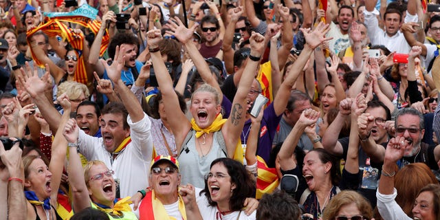 People celebrate after the Catalan regional parliament passes the vote of independence from Spain in Barcelona.