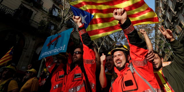 Firemen shout slongans under an Estelada (Catalan separatist flag) during a march in Barcelona, Spain, October 27, 2017.