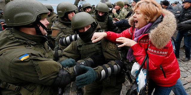A supporter of Georgian former President Mikheil Saakashvili clashes with National Guard officers in Kiev.