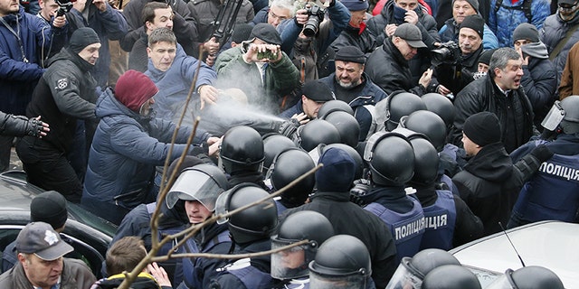 Police officers use tear gas against supporters of Georgian former President Mikheil Saakashvili during clashes.