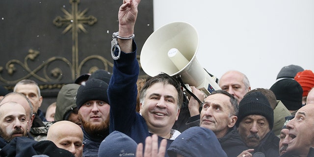 Saakashvili flashes a victory sign after he was freed by his supporters in Kiev.