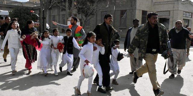 Policemen guide people after gunmen attacked the Bethel Memorial Methodist Church in Quetta, Pakistan.