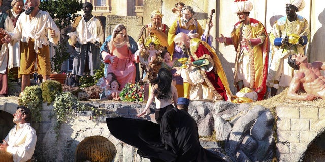 The woman was able to grab the baby Jesus statue before a police officer detained her.
