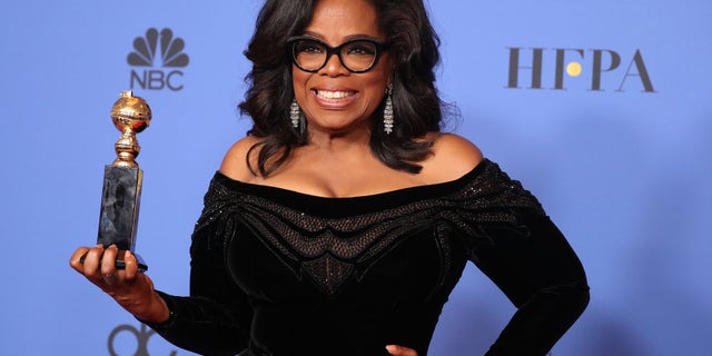 Oprah Winfrey poses backstage with her Cecil B. DeMille Award.