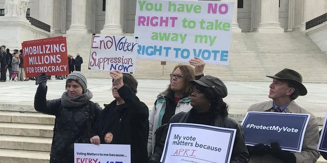 Activists rally outside the U.S. Supreme Court ahead of arguments in a key voting rights case involving a challenge to the Ohio's policy of purging infrequent voters from voter registration rolls.