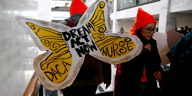 Protesters calling for an immigration bill addressing the so-called Dreamers, walk through the Hart Office Building on Capitol Hill.
