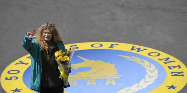 Roberta "Bobbi" Gibb , the first woman to finish the Boston Marathon 50 years ago in 1966, waves to the crowd after ceremonially breaking a finish-line tape during the 120th running of the Boston Marathon in 2016.