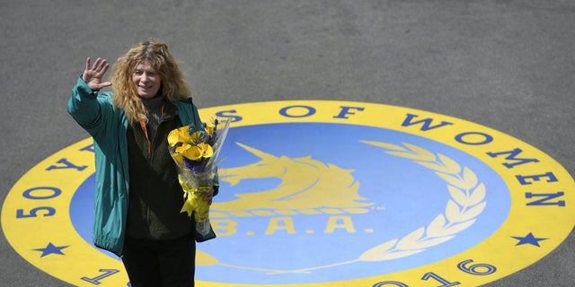 Roberta "Bobbi" Gibb , the first woman to finish the Boston Marathon 50 years ago in 1966, waves to the crowd after ceremonially breaking a finish-line tape during the 120th running of the Boston Marathon in 2016.
