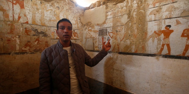 A guide from the Ministry of Antiquities inspects a discovery from Egypt’s antiquities authorities at the Giza plateau, the site of the three ancient pyramids on the outskirts of Cairo, Egypt.