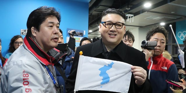 The "Kim" impersonator held up a unification flag after being kicked out of a ice hockey game.