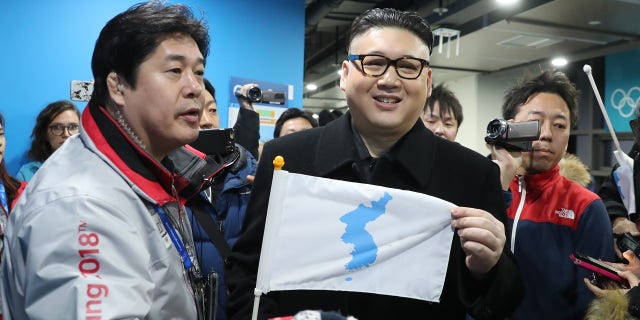The "Kim" impersonator held up a unification flag after being kicked out of a ice hockey game.