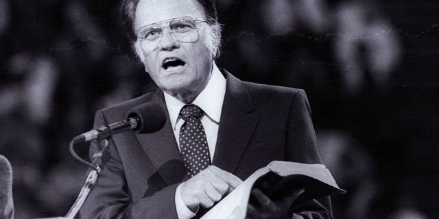 In this photo, Billy Graham is preaching the Gospel to thousands in Paris as part of his worldwide crusades in 1986.