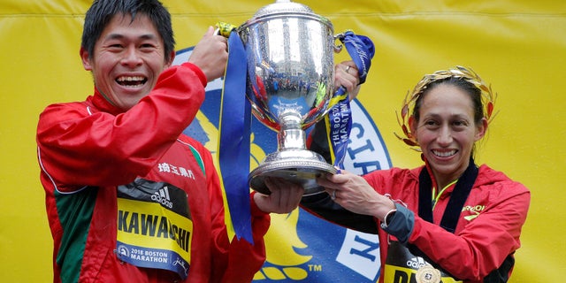 Yuki Kawauchi of Japan and Desiree Linden of the U.S. celebrate with the trophy after winning the men's and women's divisions of the 122nd Boston Marathon.