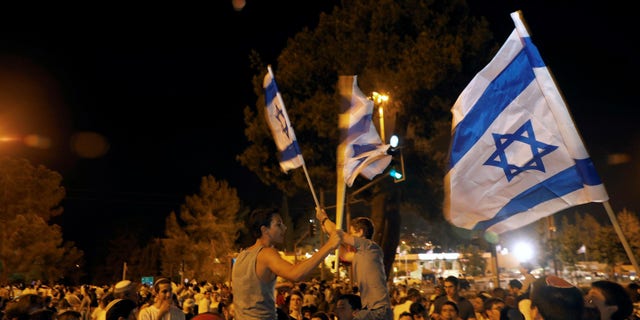 FILE -- Israelis dance with Israeli national flags during celebrations marking Israel's 70th Independence Day in Jerusalem April 18, 2018.
