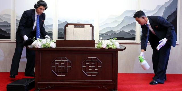 North Korean security officers check and prepare a desk before North Korean leader Kim Jong Un signs a guestbook at the truce village of Panmunjom inside the demilitarized zone separating the two Koreas, South Korea, April 27, 2018.
