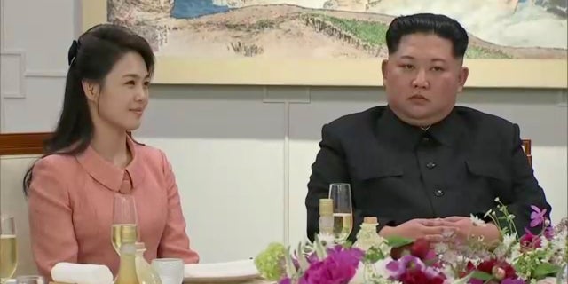 Kim Jong Un appeared to push a photographer out of the way for his wife.