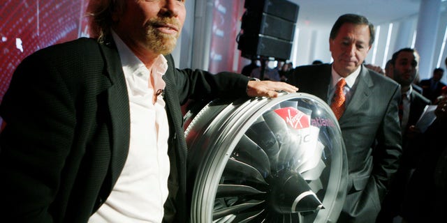 FILE -- Virgin founder and chairman Richard Branson poses with a bio-fuel Rolls-Royce Trent 1000 engine during an interview in New York, on March 3, 2008.