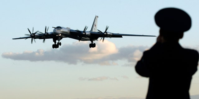 A Russian officer takes a picture of a Tu-95 bomber, or "Bear," at a military airbase in Engels, some 900 km (559 miles) south of Moscow, August 7, 2008.  Picture taken August 7, 2008. Two Tu-160 jets, known to Russian pilots as "White Swans" flew this month from this base on the Volga river to Venezuela, a mission calculated to show Russia was not afraid to flex its military muscles right under the nose of the United States.To match feature RUSSIA-BOMBERS/ REUTERS/Sergei Karpukhin  (RUSSIA) - RTX8W9J