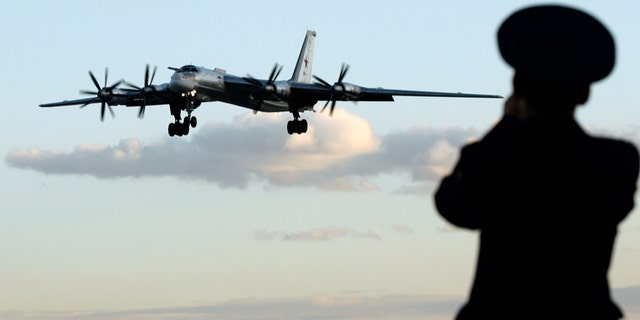 A Russian officer takes a picture of a Tu-95 bomber, or "Bear," at a military airbase in Engels, some 900 km (559 miles) south of Moscow, August 7, 2008. Picture taken August 7, 2008. Two Tu-160 jets, known to Russian pilots as "White Swans" flew this month from this base on the Volga river to Venezuela, a mission calculated to show Russia was not afraid to flex its military muscles right under the nose of the United States.To match feature RUSSIA-BOMBERS/ REUTERS/Sergei Karpukhin (RUSSIA) - RTX8W9J