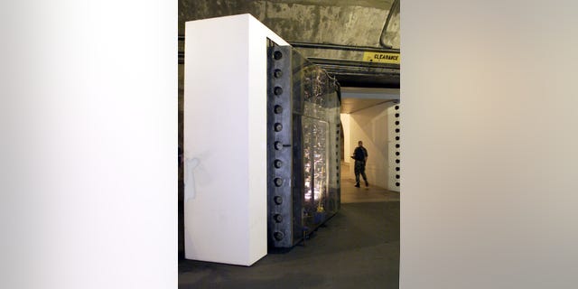 A armed guard walks past a blast-proof 25-ton steel door protecting the Cheyenne Mountain complex, home of NORAD. Picture taken October 14, 1999.