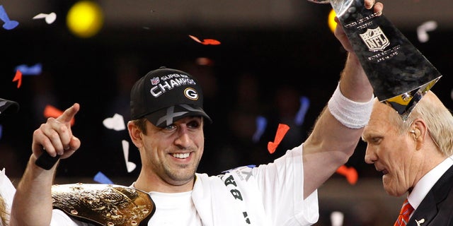 Green Bay Packers MVP quarterback Aaron Rodgers celebrates with the Vince Lombardi trophy after the Packers defeated the Pittsburgh Steelers in the NFL's Super Bowl XLV football game in Arlington, Texas, February 6, 2011.