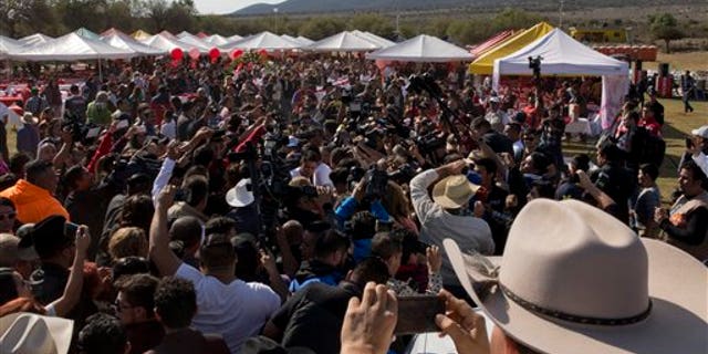 Rubi Ibarra, not seen, arrives at the site of a Mass that is part of her down-home 15th birthday party, surrounded by a horde of journalists and a drone flying overhead, in the village of La Joya, San Luis Potosi State, Mexico, Monday, Dec. 26, 2016.