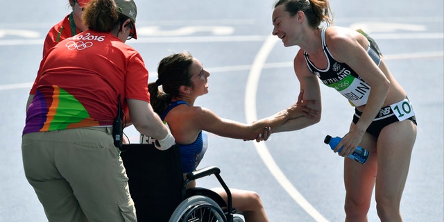 New Zealand's Nikki Hamblin greets the United States' Abbey D'Agostino, left, as she is helped from the track.