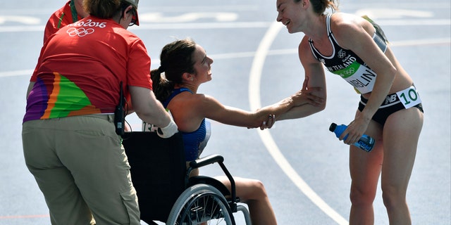 New Zealand's Nikki Hamblin greets the United States' Abbey D'Agostino, left, as she is helped from the track.